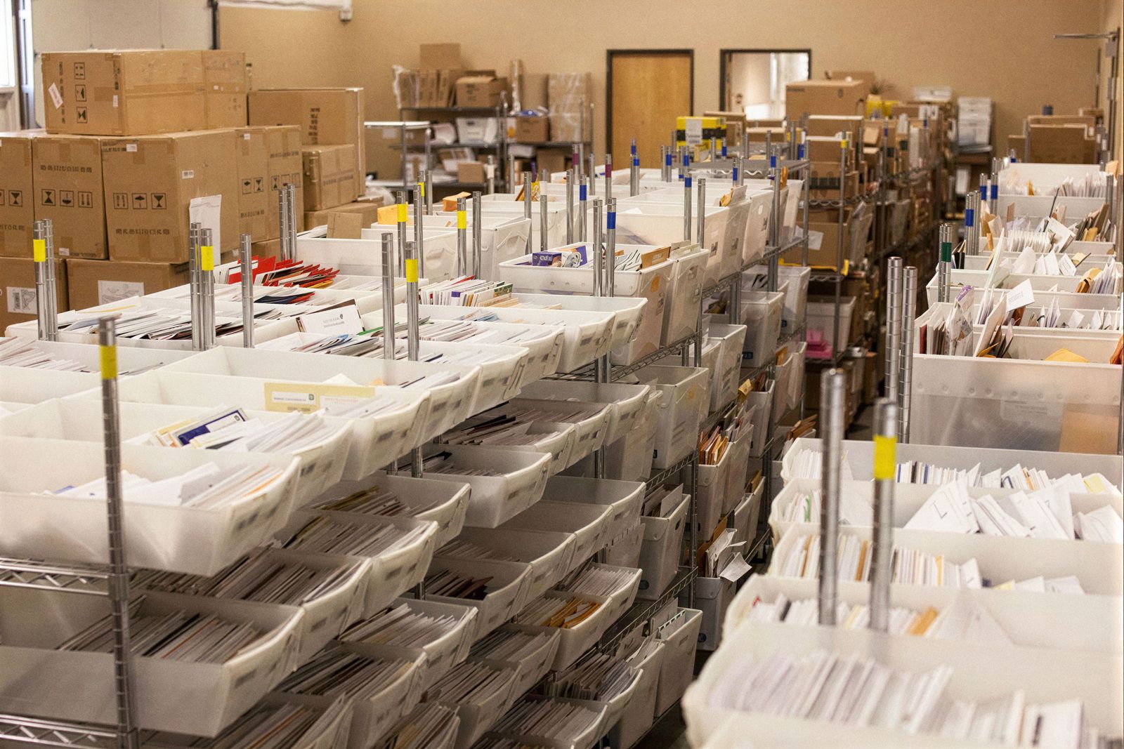 The Earth Class Mail mailroom: racks of daily mail tubs